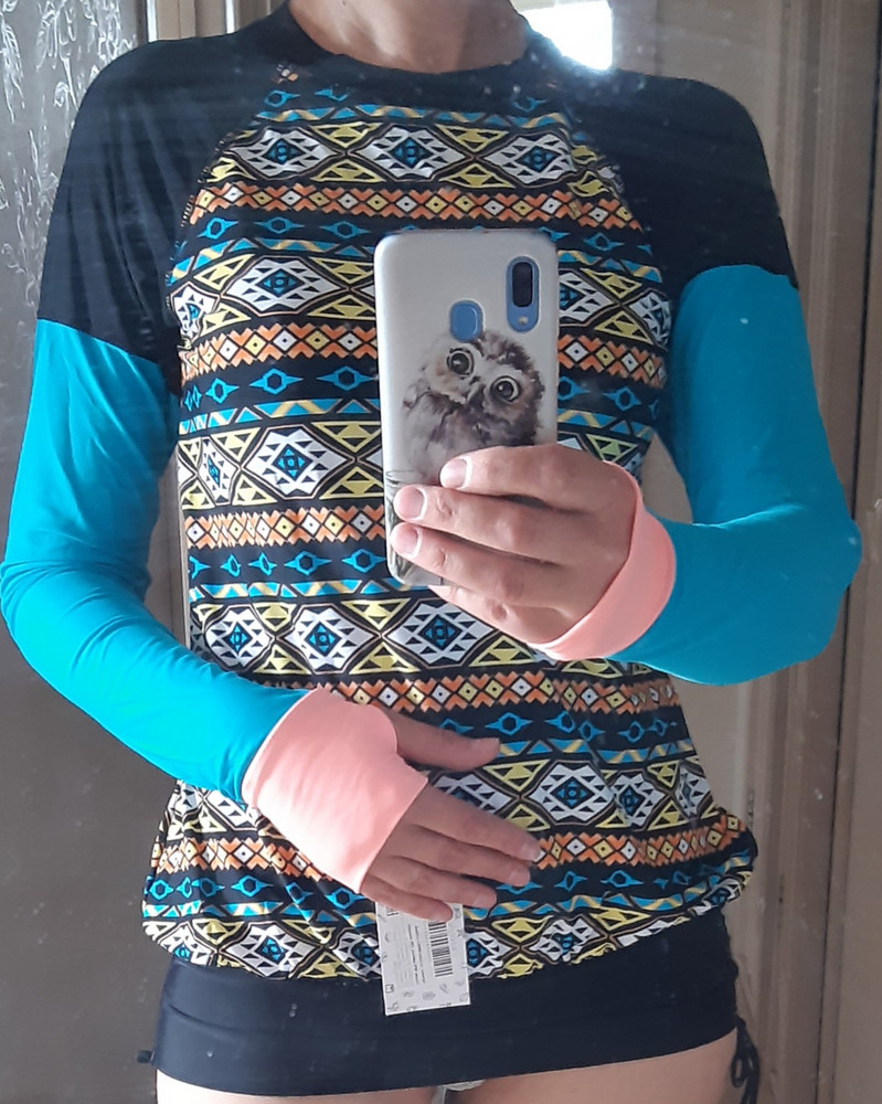 Отличная  кофта! Ткань мягкая, приятная, швы аккуратные, не врезаются нигде. Расцветка соответствует фото, яркая. Фасон с напуском немного. Топ с чашками внутри высоко расположен, но я изначально планировала его отрезать, чтобы одевать на купальник сверху на время плавания. Размер L соответствует размерной таблице. На мой рост 170 и параметры ( ГхТхБ) 89х75х99 села отлично. Рекомендую.