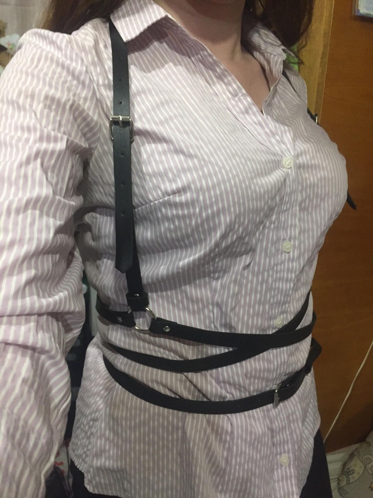 Вещь отличная, ремешки ровные, фурнитура на месте. Слегка чувствуется запах от кожи, но не резкий. Приложила несколько фото на разную одежду. Шлёвка будет спадать. Для себя решила приклеить её к верхней стороне язычка ремня. Так, чтобы можно было регулировать. На фото держу пальцами это место. У кого возникнут проблемы с примеркой, совет: 1 найти симметрию в этой конструкции, 2 соединить боковые ремни, 3 надеть как куртку. 